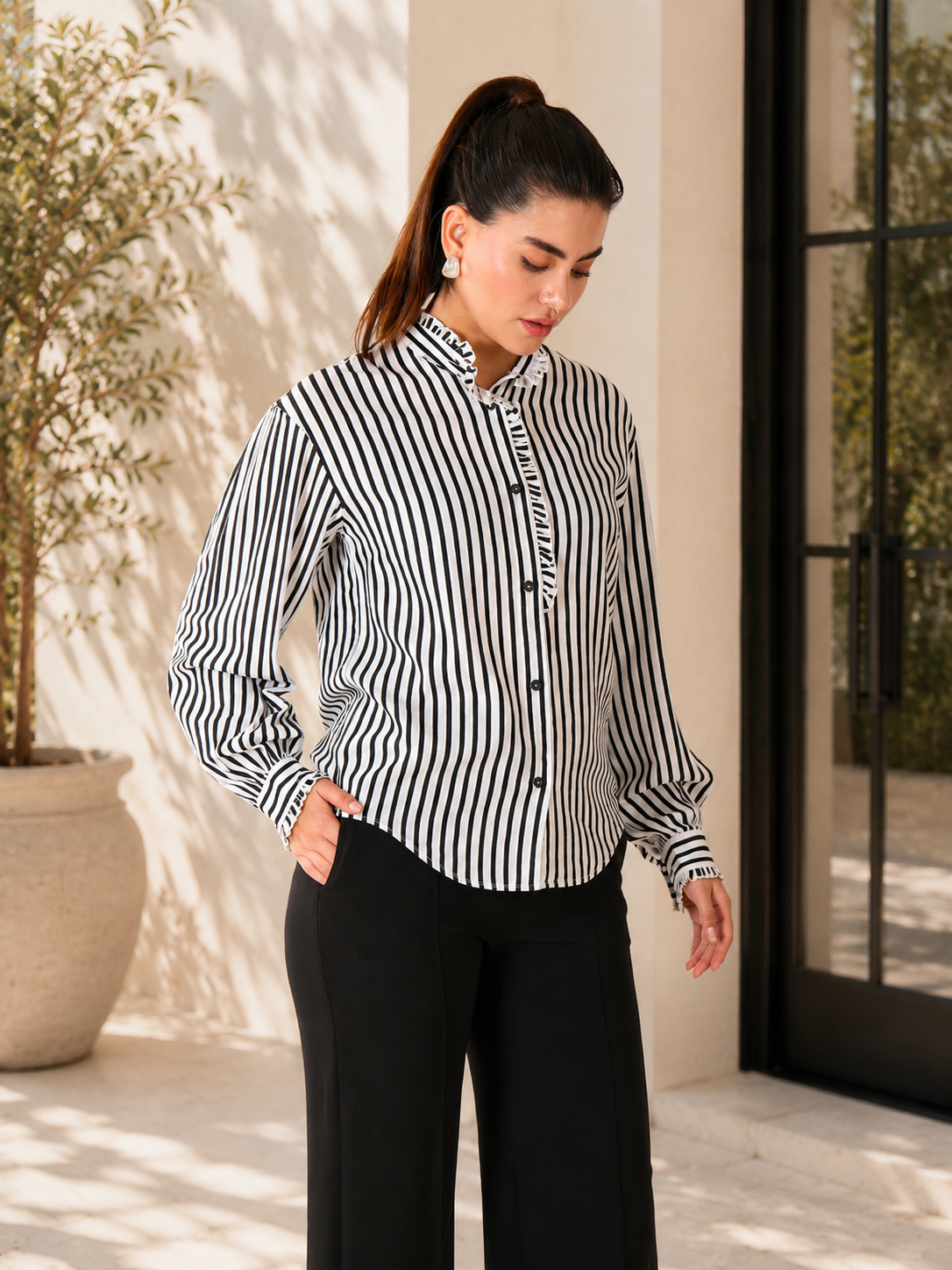 Chemise à rayures verticales noires et blanches et col à volants