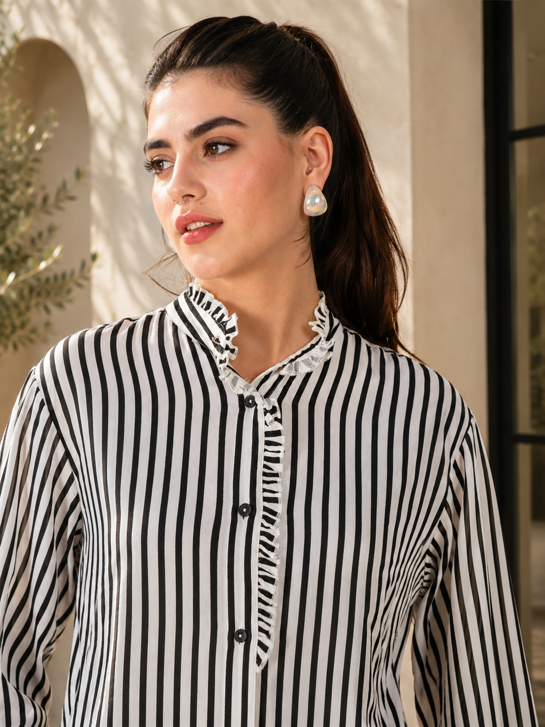 Camisa con cuello con volantes y rayas verticales en blanco y negro